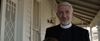 Movie still from “Annabelle: Creation” (2017), directed by David F. Sandberg – An older man wearing a priest's outfit; Close Up shot, Over the shoulder angle
