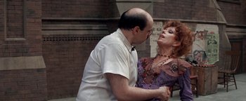 Movie still from “Annie” (1982), directed by John Huston – A man and a woman are dancing on the street; Medium shot, Over the shoulder angle