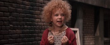 Movie still from “Annie” (1982), directed by John Huston – A young child with a curly hair and a red sweater; Close Up shot, High angle