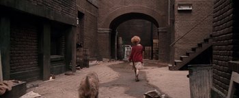 Movie still from “Annie” (1982), directed by John Huston – A child and a dog walking down a brick path; Wide shot, High angle