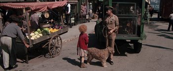 Movie still from “Annie” (1982), directed by John Huston – A woman and a dog on the sidewalk; Wide shot, High angle