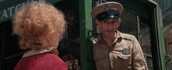 Movie still from “Annie” (1982), directed by John Huston – A man wearing a hat standing next to a woman; Close Up shot, Over the shoulder angle