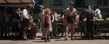 Movie still from “Annie” (1982), directed by John Huston – A group of people standing on the side of the street; Wide shot, High angle