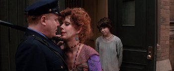 Movie still from “Annie” (1982), directed by John Huston – A man and a woman and a child in a room; Medium shot, Over the shoulder angle