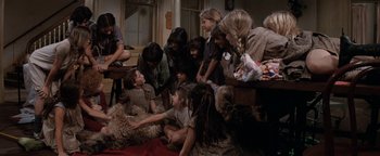 Movie still from “Annie” (1982), directed by John Huston – A group of people sitting around a dog; Wide shot, High angle