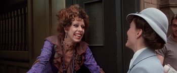 Movie still from “Annie” (1982), directed by John Huston – A woman with red curly hair smiling for the camera; Close Up shot, Low angle