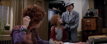 Movie still from “Annie” (1982), directed by John Huston – Two women and a little girl in a room; Medium shot, Over the shoulder angle
