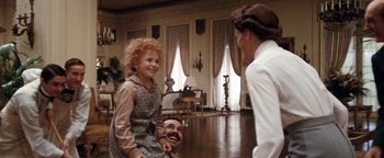 Movie still from “Annie” (1982), directed by John Huston – A woman and a little girl in a living room; Wide shot, Over the shoulder angle