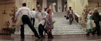 Movie still from “Annie” (1982), directed by John Huston – A group of young people dancing in front of a staircase; Wide shot, High angle