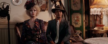 Movie still from “Annie” (1982), directed by John Huston – A man and a woman sitting next to each other in a room; Medium shot, High angle