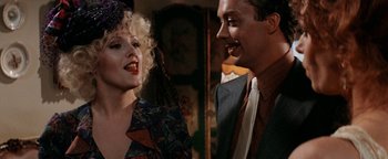 Movie still from “Annie” (1982), directed by John Huston – A man and a woman smiling at each other in a room; Close Up shot, Over the shoulder angle