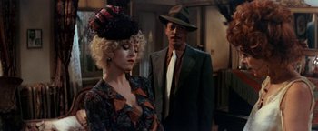 Movie still from “Annie” (1982), directed by John Huston – A man and a woman standing next to each other; Close Up shot, Over the shoulder angle