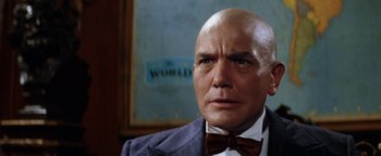 Movie still from “Annie” (1982), directed by John Huston – An older bald man wearing a suit and bow tie; Close Up shot, Low angle
