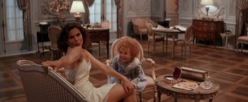 Movie still from “Annie” (1982), directed by John Huston – A woman and a child sitting on a chair in a living room; Medium shot, Over the shoulder angle