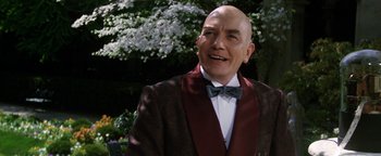 Movie still from “Annie” (1982), directed by John Huston – A bald man in a suit and bow tie; Close Up shot, Over the shoulder angle