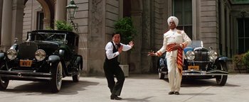 Movie still from “Annie” (1982), directed by John Huston – A man in a white turban and a man in a black suit; Wide shot, Low angle