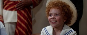 Movie still from “Annie” (1982), directed by John Huston – A young child with a red curly hair and a sailor suit; Close Up shot, High angle
