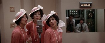 Movie still from “Annie” (1982), directed by John Huston – A couple of people that are in a room; Medium shot, Over the shoulder angle