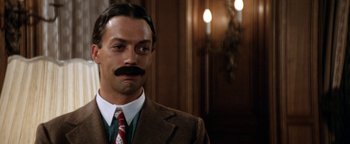 Movie still from “Annie” (1982), directed by John Huston – A person wearing a suit and tie; Close Up shot, Low angle