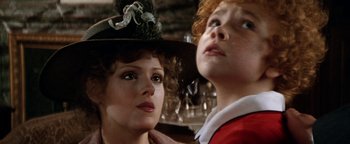 Movie still from “Annie” (1982), directed by John Huston – A woman and a boy wearing a hat and looking at the camera; Close Up shot, Low angle