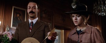 Movie still from “Annie” (1982), directed by John Huston – A man and a woman standing next to each other holding papers; Close Up shot, Low angle