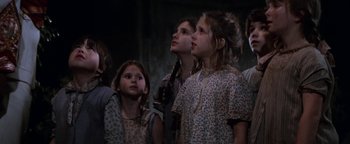 Movie still from “Annie” (1982), directed by John Huston – A group of young girls standing next to each other; Medium shot, Low angle