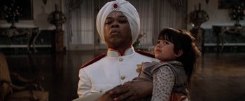 Movie still from “Annie” (1982), directed by John Huston – A man in a turban holding a little girl; Close Up shot, Low angle