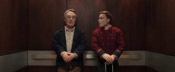 Movie still from “Anomalisa” (2015), directed by Duke Johnson – A man and a man in a uniform in an elevator; Medium shot, Low angle