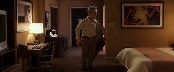 Movie still from “Anomalisa” (2015), directed by Duke Johnson – An older man holding an open umbrella in a room; Wide shot, Over the shoulder angle