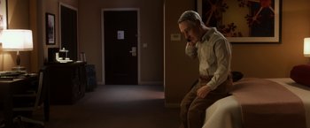 Movie still from “Anomalisa” (2015), directed by Duke Johnson – A man sitting on a bed in a dark room; Wide shot, High angle
