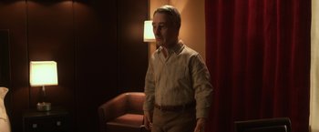 Movie still from “Anomalisa” (2015), directed by Duke Johnson – A man standing in front of a chair in a room; Medium shot, High angle