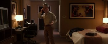 Movie still from “Anomalisa” (2015), directed by Duke Johnson – A man standing in a room talking on a phone; Medium shot, High angle