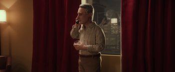 Movie still from “Anomalisa” (2015), directed by Duke Johnson – A man talking on a cell phone while holding a drink; Medium shot, Low angle