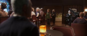 Movie still from “Anomalisa” (2015), directed by Duke Johnson – A group of people sitting at a table in front of a candle; Wide shot, Over the shoulder angle