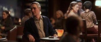 Movie still from “Anomalisa” (2015), directed by Duke Johnson – A man sitting at a table in front of a glass of beer; Medium shot, Over the shoulder angle