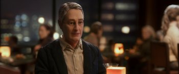 Movie still from “Anomalisa” (2015), directed by Duke Johnson – A man sitting at a table in a room; Close Up shot, Over the shoulder angle