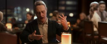Movie still from “Anomalisa” (2015), directed by Duke Johnson – An older man is sitting at a table with his hands outstreched; Close Up shot, Over the shoulder angle
