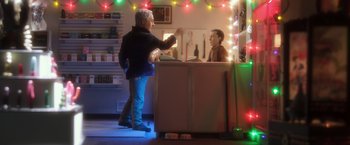 Movie still from “Anomalisa” (2015), directed by Duke Johnson – A man standing in front of a counter with a man sitting at the counter; Medium shot, Over the shoulder angle