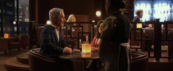 Movie still from “Anomalisa” (2015), directed by Duke Johnson – A group of people sitting at a table with a lamp; Medium shot, Over the shoulder angle