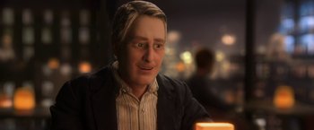 Movie still from “Anomalisa” (2015), directed by Duke Johnson – A man in a suit and striped shirt is sitting at a table; Close Up shot, Over the shoulder angle