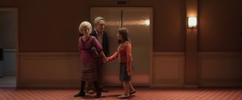 Movie still from “Anomalisa” (2015), directed by Duke Johnson – A woman and a man and a little girl holding hands in front of an elevator; Wide shot, Low angle