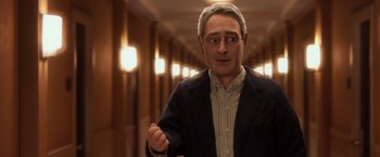 A man wearing a suit and tie in a hallway
