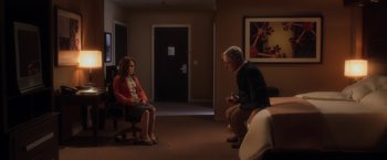 Movie still from “Anomalisa” (2015), directed by Duke Johnson – A man and a woman sitting on a chair in front of a door; Wide shot, High angle