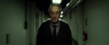 A man in a suit and tie in a dark hallway