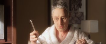 Movie still from “Anomalisa” (2015), directed by Duke Johnson – An older man in a white bathrobe holding a tooth brush; Close Up shot, High angle