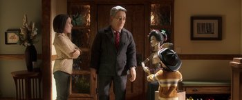 Movie still from “Anomalisa” (2015), directed by Duke Johnson – A man in a business suit standing in front of two dolls; Medium shot, Over the shoulder angle