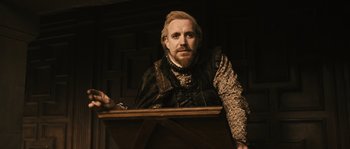 Movie still from “Anonymous” (2011), directed by Roland Emmerich – A man with a long beard and mustache wearing medieval clothing; Medium shot, Over the shoulder angle