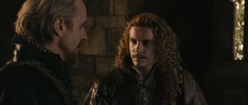 Movie still from “Anonymous” (2011), directed by Roland Emmerich – A man with long hair and a beard standing next to another man with long hair; Close Up shot, Over the shoulder angle