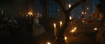 Movie still from “Anonymous” (2011), directed by Roland Emmerich – A group of people sitting around a tree with candles; Wide shot, High angle