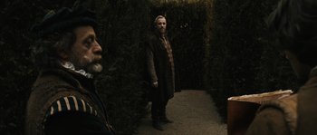 Movie still from “Anonymous” (2011), directed by Roland Emmerich – A man standing next to another man on a path; Wide shot, Over the shoulder angle